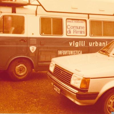 immagine del pulmino Fiat 850 in uso all'Ufficio infortunistica dei Vigili Urbani di Rimini, chiamata Zebra 14, utilizzata per la missione di soccorso alle popolazioni terremotate in Irpinia. Davanti si è un auto civile marca Talbot