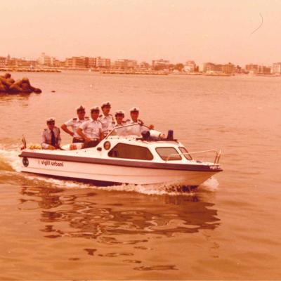 immagine del motoscafo con i Vigili a bordo all'uscita del portocanale. Sullo sfondo la spiaggia di San Giuliano mare prima della costruzione della darsena 