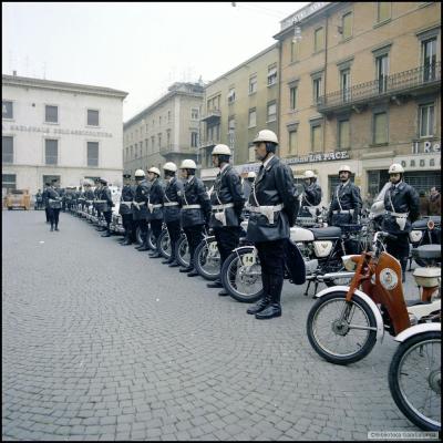 immagine di una parte del Corpo dei Vigili Urbani schierato in piazza Cavour il 17 gennaio 1976. In primo piano i Vigili motociclisti con le honda Four 350. Sullo sfondo la banca Nazionale dell'Agricoltura all'intersezione con via Gambalunga