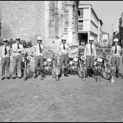 immagine di un gruppo di Vigili motociclisti fotografata davanti all'Arco d'Augusto. Le Honda Four in uso al tempo, hanno davanti dei numeri poiché hanno partecipato a delle gare. Sullo sfondo il corso d'Augusto con le varie insegne   