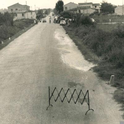 un'immagine della via Marecchiese direzione mare monte al Km 85 + 700 ( 1968 ) nel tratto compreso tra la via Novafeltria e Montemaggio. Ai lati della carreggiata delle abitazioni. Sul lato destro della foto un auto ferma con alcune persone attorno