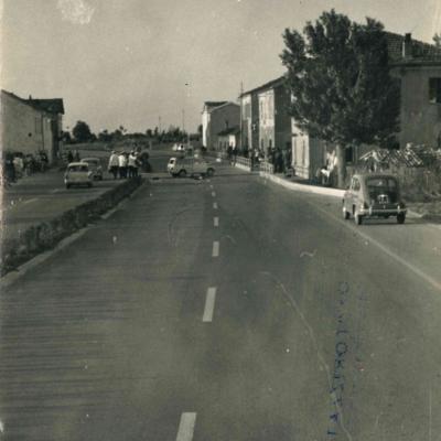 Foto panoramica della Strada Consolare Rimini - San Marino in località Fornace Marchesini direzione San Marino (1962). Al centro della carreggiata si vedono i Vigili intenti a rilevare un sinistro, sullo sfondo il gruppo di case e delle che osservanoe