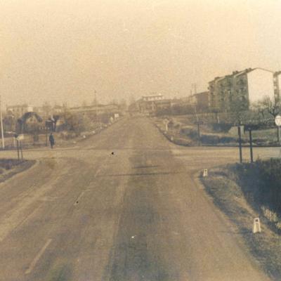 immagine dell'intersezione della strada statale 72 ora via della Repubblica, con la via Flaminia Conca (1965). Sul lato destro vi è un cartello pubblicitario "La Lanterna", sullo sfondo i palazzi delle case popolari, in fondo l'attuale via Fada