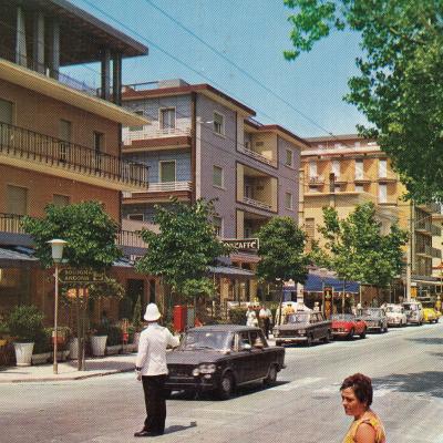 anni '70. Intersezione viale Regina Margherita viale Catania con un Vigile con cappello coloniale al centro dell'intersezione impegnato a dirigere. Sullo sfondo i negozi lungo il viale Regina Margherita 